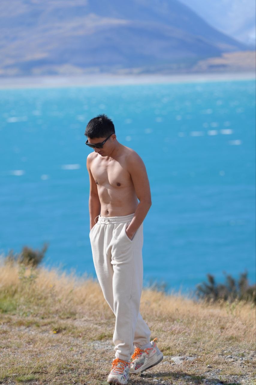 Adam Young standing beside a blue lake